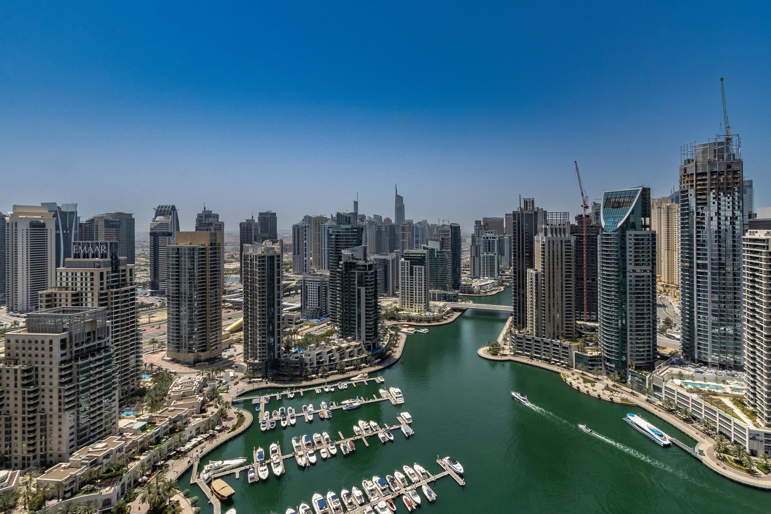 Stunning aerial view of Dubai Marina's skyline and waterway under a clear blue sky.